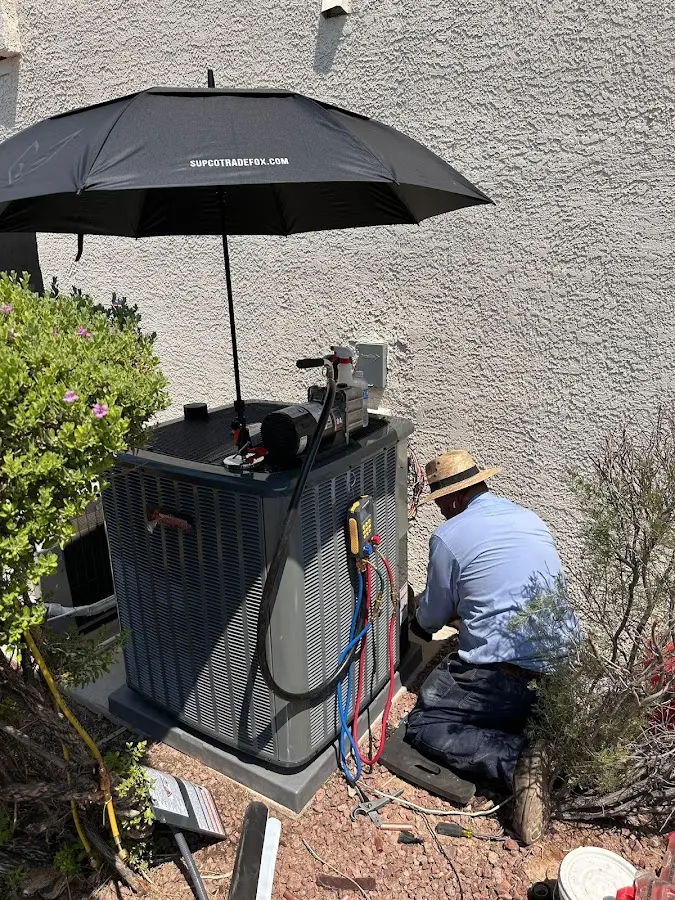 HVAC technician performing outdoor AC maintenance in Milford